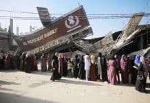 People standing in line in front of a bakery in Gaza