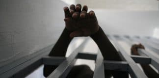 Boys reach through bars at a jail for juveniles in the Delmas neighbourhood of Port-au-Prince, Haiti. 2005