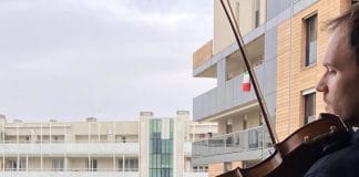 Aldo Sebastián Cicchini, a violinist at RAI orchestra plays on a balcony in Milan, Italy during the COVID-19.