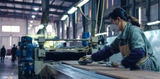 A worker cleans finished wood flooring in a factory in Zhejiang, China.