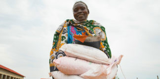 A woman carries sacks of seeds distributed to families in South Sudan during the COVID-19 pandemic.