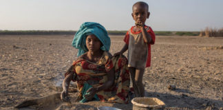 A young girl cooks in a rural village in Ethiopia, where the land has been affected by recurrent droughts.