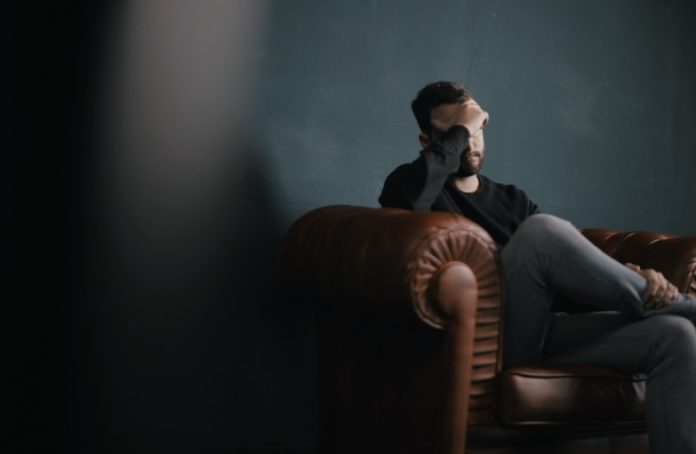 Man sitting on sofa | Photo by Nik Shuliahin on Unsplash