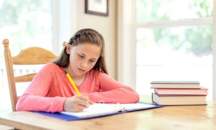 Girl writing letter at table