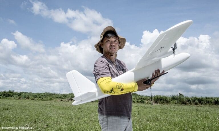 Farmer holding miniature plane | © Veejay Villafranca