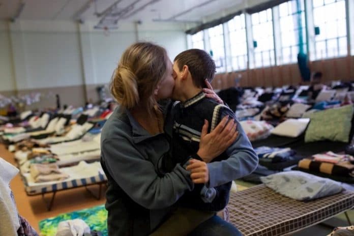 A refugee from Ukraine hugs her son in a reception centre set up in the sports hall of a school in the Polish border town of Medyka.