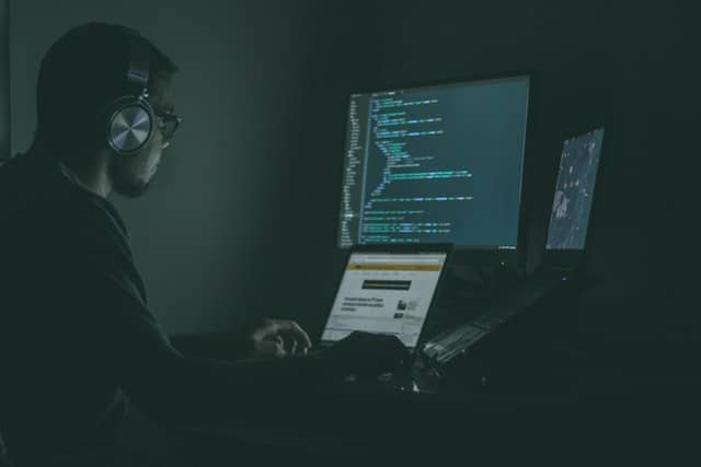 Man in front of several computers