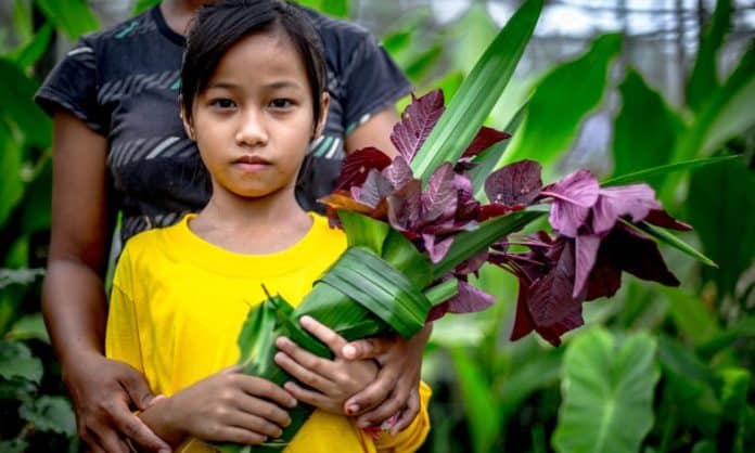 Indigenous person holding flowers