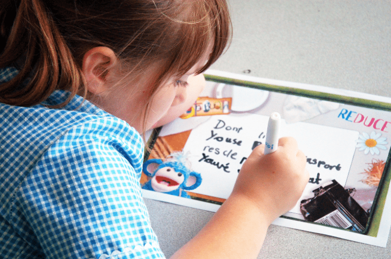 A young student making a Wastebuster poster in school for Waste Week