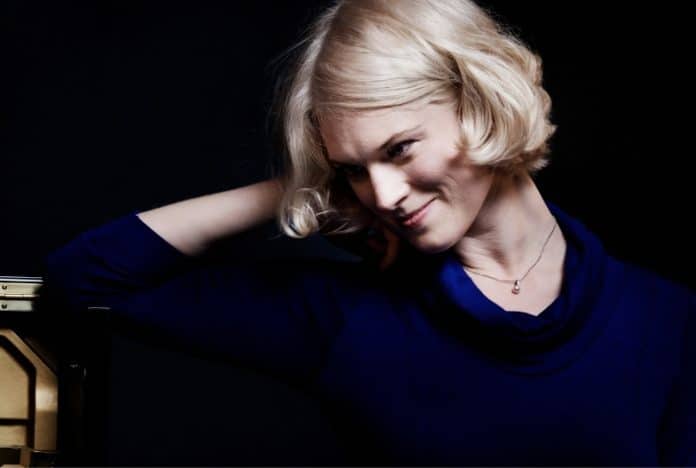 A headshot of Emilie Conway leaning on her hand.