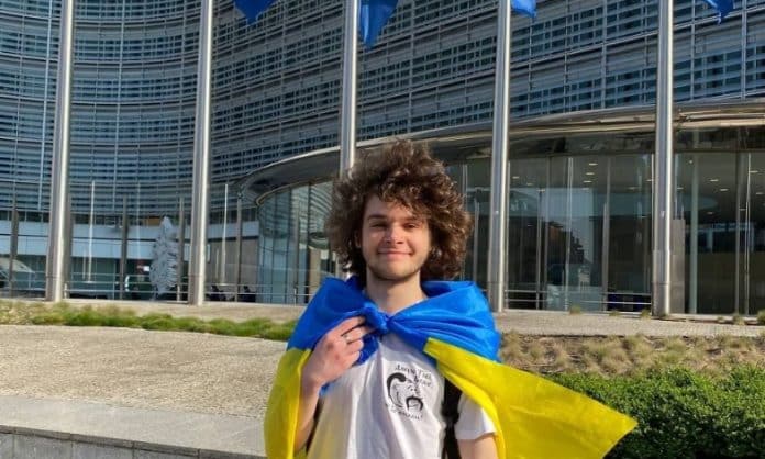 Ukrainian student holding Ukrainian flag in front of Berlaymint