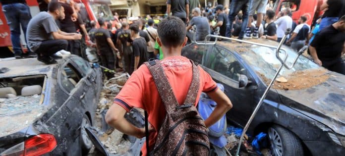 People gather around a bombed building in a southern suburb of Beirut.