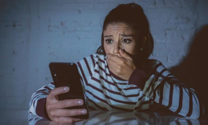 Young women looking at her mobile phone, worried.