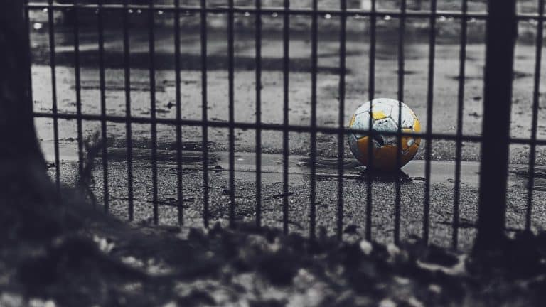 Orange and green football on road.