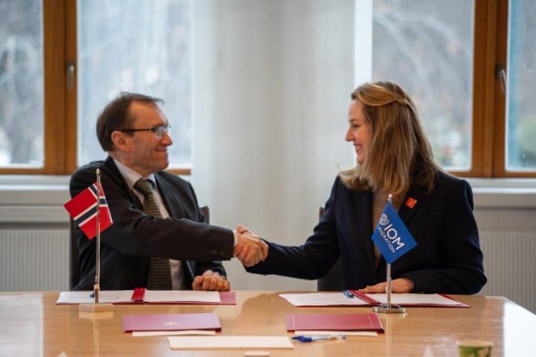 A man and a woman shaking hands in a formal setting