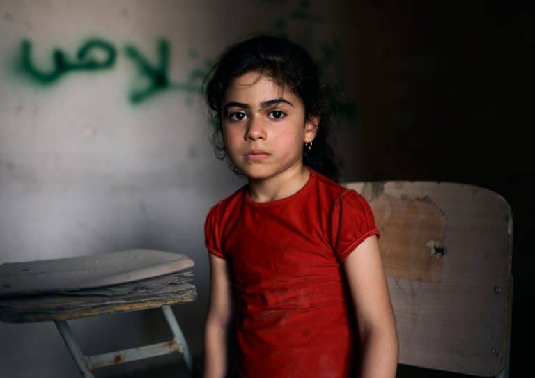 Tabarak, 6, Iraq. Tabarak lives in the war-torn western district in the old city of Mosul. She sits in an empty classroom at Al-Ekhlas primary school in the Nabi Jarjis neighbourhood.