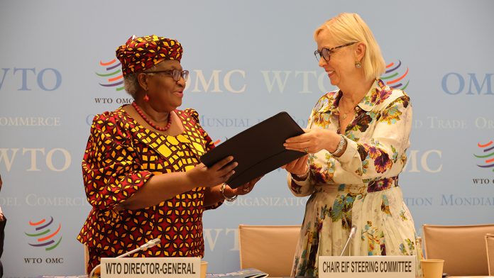 Two women in an official setting sharing documents