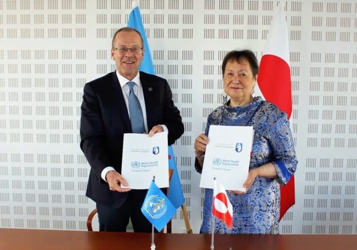 A man and a woman in an official setting holding documents.