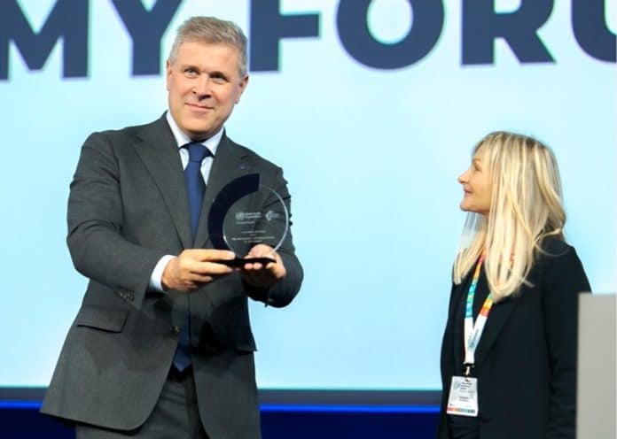 A man holding a reward next to a woman