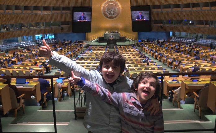 Two children in front of a huge meeting hall