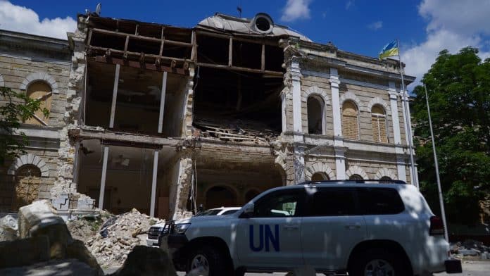 War damaged building with a car that says UN