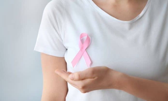 Breast Cancer Awareness - a women in a white t-shirt with a pink ribbon