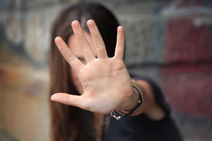 Women with her hand held out defensively - used as cover for an article on Femicide in Belgium