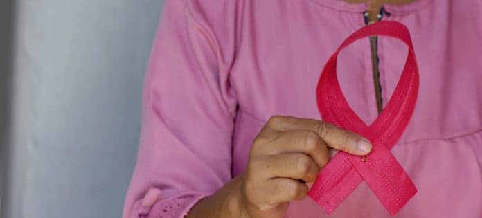 © Unsplash/Angiola Harry Una mujer sujeta un lazo rosa en conmemoración del Día contra el Cáncer de Mama.