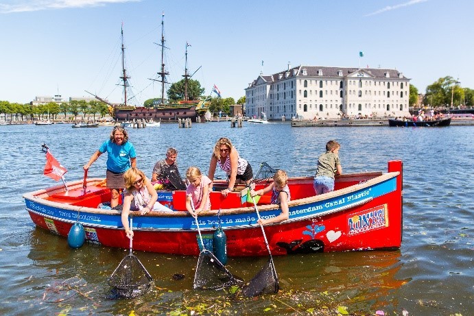 Des gens sur un bateau qui ramassent des déchets