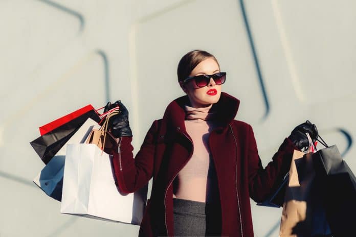 Une femme avec de nombreux sacs d'achat de vêtement