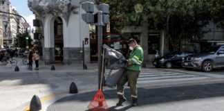 Un éboueur travaillant avec un masque sur le visage dans une rue