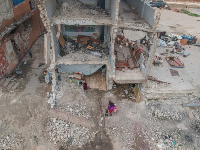 Bâtiment en ruine où se dirige une femme et un enfant