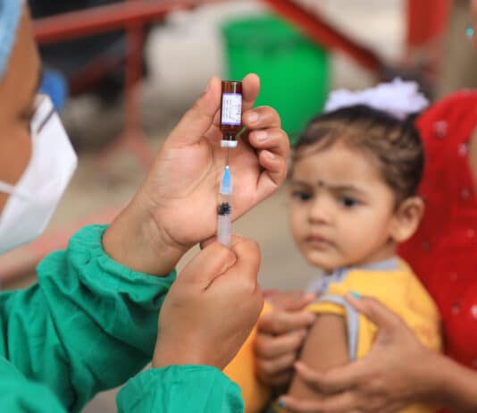 Des agents de santé dans un centre de vaccination à Kalanki, dans la capitale du Népal, Katmandou, se préparent à administrer le vaccin contre la rougeole et la rubéole aux enfants amenés par leurs parents, le 2 juillet 2020.