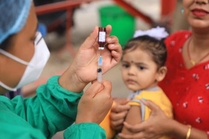 Des agents de santé dans un centre de vaccination à Kalanki, dans la capitale du Népal, Katmandou, se préparent à administrer le vaccin contre la rougeole et la rubéole aux enfants amenés par leurs parents, le 2 juillet 2020.