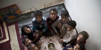 enfants assis autour d'un plat ne contenant que quelques feuilles