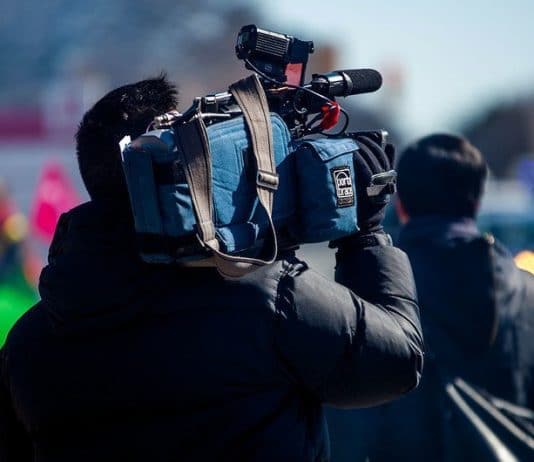 Journaliste de télévision, caméra sur l'épaule