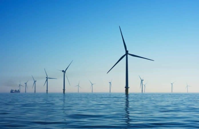 Photo d'un champ d'éoliennes, dans la mer.