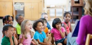 enfants dans une salle de classe, assis par terre