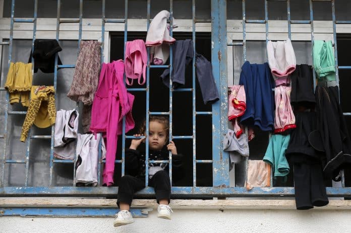 Un enfant derrière un balcon dans l'une des écoles de l'UNRWA qui sert d'abri aux déplacés dans la bande de Gaza.