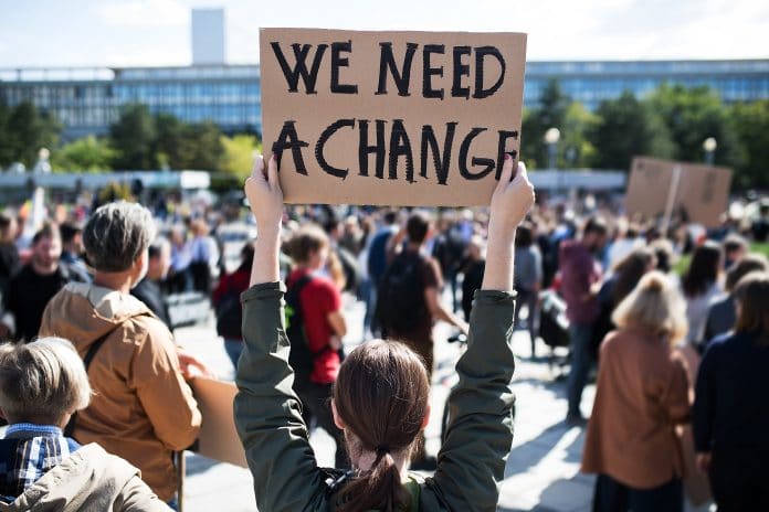 Rear,View,Of,People,With,Placards,And,Posters,On,Global climate change