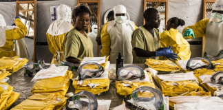 Gli operatori sanitari indossano dispositivi di protezione individuale (DPI) prima di entrare in una zona di quarantena Ebola nella Repubblica Democratica del Congo.