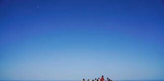 rifugiati e migranti alla deriva in una barca di legno aspettano di essere salvati vicino all'isola italiana di Lampedusa nel Mar Mediterraneo