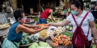 IMF:Lisa Marie David A vegetable vendor serves a customer at a market in Manila, Philippines.