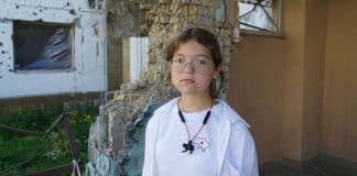 © UNICEF 11-year-old Katya stands on the territory of the Irpin school, which was heavily bombed in March 2022.