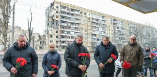 High Commissioner Filippo Grandi (centre), alongside representatives of local authorities, lays flowers at a residential building that was destroyed during a missile strike on 14 January 2023, in Dnipro city, Ukraine