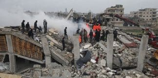 Rescue workers look for survivors in a building in Samada, Syria