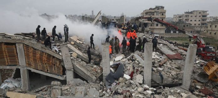 Rescue workers look for survivors in a building in Samada, Syria