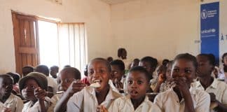 In questa foto i bambini mangiano il pranzo a scuola