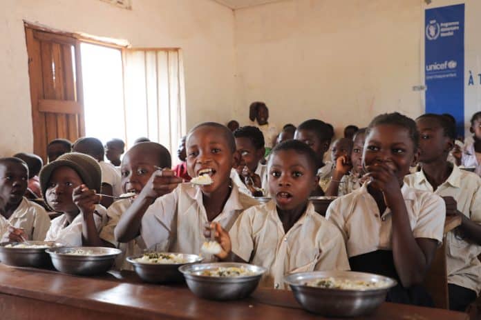 In questa foto i bambini mangiano il pranzo a scuola