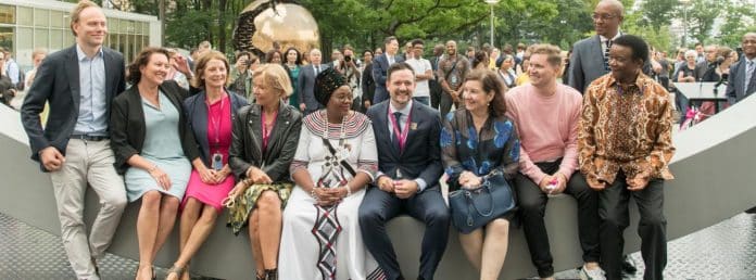 donne e uomini diplomatici seduti a parlare e ridere fra loro